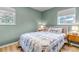 Cozy bedroom featuring light green walls, two windows, and patterned bedding with matching pillows at 3550 Magnolia St, Denver, CO 80207
