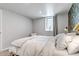 Cozy bedroom features plush bedding, soft lighting and an airy window at 3550 Magnolia St, Denver, CO 80207