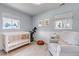 Charming Bedroom with a white crib, soft gray chair, and natural light from multiple windows at 3550 Magnolia St, Denver, CO 80207