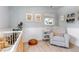 Comfortable Bedroom featuring a plush chair, white crib, and decorative touches for a serene atmosphere at 3550 Magnolia St, Denver, CO 80207