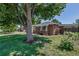 Charming brick home with a beautiful mature tree and well-kept lawn at 3550 Magnolia St, Denver, CO 80207