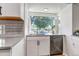 Updated kitchen with white cabinets, stainless steel dishwasher and a large window overlooking the front yard at 3550 Magnolia St, Denver, CO 80207