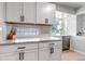 Modern kitchen boasts white cabinets, glass backsplash, gray countertop, and stainless steel appliances at 3550 Magnolia St, Denver, CO 80207