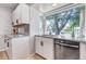 Bright kitchen with white cabinets, gray countertops, stainless steel appliances and view to the outside at 3550 Magnolia St, Denver, CO 80207