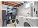 Functional laundry area with washer, dryer, and ample storage shelving at 3550 Magnolia St, Denver, CO 80207