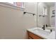 Powder room featuring a light-colored quartz countertop, wooden vanity, and a mirror at 12333 Newport Ct, Brighton, CO 80602