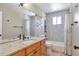 Bathroom features a light-colored granite countertop, wooden vanity, large mirror, and tiled bathtub at 12333 Newport Ct, Brighton, CO 80602