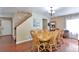 Bright dining room with hardwood floors, a charming light fixture, and comfortable seating for Gathering meals at 12333 Newport Ct, Brighton, CO 80602