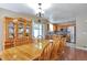 Open-concept dining room features hardwood floors, a wooden dining table, and an antique hutch at 12333 Newport Ct, Brighton, CO 80602