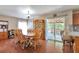 Bright dining room features hardwood floors, a wooden dining table, and sliding door access to the backyard at 12333 Newport Ct, Brighton, CO 80602