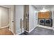 Efficient laundry room with modern washer and dryer, plus ample cabinet storage and sleek gray wood-look floors at 12333 Newport Ct, Brighton, CO 80602