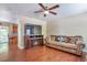 Comfortable living room featuring a cozy fireplace, hardwood floors, and a ceiling fan for added comfort at 12333 Newport Ct, Brighton, CO 80602