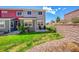 Spacious backyard featuring a lush green lawn, small patio and retaining wall at 4027 E 98Th Pl, Thornton, CO 80229