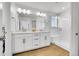 Bright bathroom featuring double vanity, modern fixtures, quartz countertops, and frameless glass shower with seat at 4027 E 98Th Pl, Thornton, CO 80229
