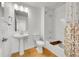 Modern bathroom features pedestal sink, soaking tub with shower, and stylish curtain at 4027 E 98Th Pl, Thornton, CO 80229