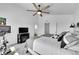 Well-lit bedroom featuring ceiling fan, large bed with pillows, TV, and exercise equipment at 4027 E 98Th Pl, Thornton, CO 80229