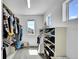 Walk-in closet with a window, filled with clothes and shoes in a well-organized manner at 4027 E 98Th Pl, Thornton, CO 80229