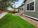 Landscaped backyard with a lawn, gravel beds, and a patio at 5377 Cloverbrook Cir, Highlands Ranch, CO 80130