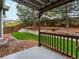 Backyard patio with stone retaining wall, wooden fence, and mature trees at 5377 Cloverbrook Cir, Highlands Ranch, CO 80130