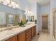 Bright bathroom featuring double sinks, tiled countertops, and a separate shower and tub at 5377 Cloverbrook Cir, Highlands Ranch, CO 80130