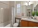 Well-lit bathroom featuring a vanity, toilet, shower-tub combo and a window with shutters at 5377 Cloverbrook Cir, Highlands Ranch, CO 80130