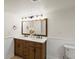 Bathroom features a double sink vanity, wood framed mirror, and modern lighting at 5377 Cloverbrook Cir, Highlands Ranch, CO 80130