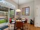 Sunlit dining area with hardwood floors, modern light fixture, and sliding glass door to patio at 5377 Cloverbrook Cir, Highlands Ranch, CO 80130