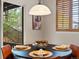 Elegant dining room with a modern light fixture and view to the outdoor patio at 5377 Cloverbrook Cir, Highlands Ranch, CO 80130