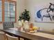 Close-up of decor on a wood dining table with a plant and natural light from the window at 5377 Cloverbrook Cir, Highlands Ranch, CO 80130