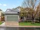 Charming home featuring a two-car garage, manicured lawn, and a cozy front porch at 5377 Cloverbrook Cir, Highlands Ranch, CO 80130