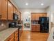 Modern kitchen showcasing granite countertops, wood cabinets, and black appliances at 5377 Cloverbrook Cir, Highlands Ranch, CO 80130