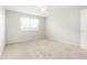 Empty bedroom featuring neutral carpet and a large window at 3855 S Monaco St # 166, Denver, CO 80237