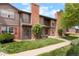 A charming townhome featuring red brick, trimmed windows, and a well-kept lawn at 3855 S Monaco St # 166, Denver, CO 80237