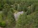 Aerial view of a house nestled among dense trees, surrounded by lush greenery and foliage at 1038 Tenderfoot Dr, Larkspur, CO 80118