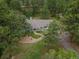 Aerial view of charming house with lush landscaping, nestled within dense tree coverage at 1038 Tenderfoot Dr, Larkspur, CO 80118