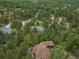 Aerial view of houses with treed surroundings in a neighborhood, showing lush, green foliage at 1038 Tenderfoot Dr, Larkspur, CO 80118