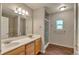 Bright bathroom featuring double sinks, tile floors, and a glass-enclosed shower for a spa-like experience at 1038 Tenderfoot Dr, Larkspur, CO 80118