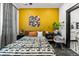 Bedroom with a mustard yellow accent wall and mid century modern decor at 3116 N Gilpin St, Denver, CO 80205