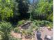 Backyard view of a fish pond and wooden deck surrounded by mature trees and garden at 1080 Ithaca Dr, Boulder, CO 80305