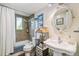 Bathroom with a bathtub shower combination, patterned tile wall, pedestal sink, and decorative mirror at 1080 Ithaca Dr, Boulder, CO 80305