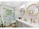 Bright bathroom featuring a glass shower, double sinks, and dual round mirrors with gold trim at 1080 Ithaca Dr, Boulder, CO 80305
