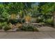 Inviting home exterior with a well-landscaped yard and driveway, partially shaded by mature trees at 1080 Ithaca Dr, Boulder, CO 80305
