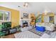 Cozy living room with fireplace, TV, neutral decor, and a bright blue ottoman at 1080 Ithaca Dr, Boulder, CO 80305