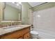 Cozy bathroom featuring a granite countertop vanity, shower and bath combo, and neutral tiling at 9960 Garland Ln, Broomfield, CO 80021