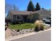 Charming single-story home with stone accents, well-maintained lawn, and attached two-car garage at 9960 Garland Ln, Broomfield, CO 80021