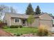Charming single-story home with stone and siding, a manicured lawn, and mature trees under a clear blue sky at 9960 Garland Ln, Broomfield, CO 80021