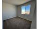 Simple bedroom with plush carpeting and a large window offering neighborhood views at 6601 N Netherland St, Aurora, CO 80019