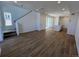 Open-concept living room featuring wood-look floors, staircase, and sliding glass door to the outside at 6601 N Netherland St, Aurora, CO 80019