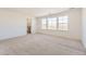 Spacious bedroom featuring three windows, carpet flooring, and a doorway to the bathroom at 907 Congress Pl, Elizabeth, CO 80107