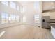 Spacious living room featuring high ceilings, large windows, and light wood floors at 907 Congress Pl, Elizabeth, CO 80107